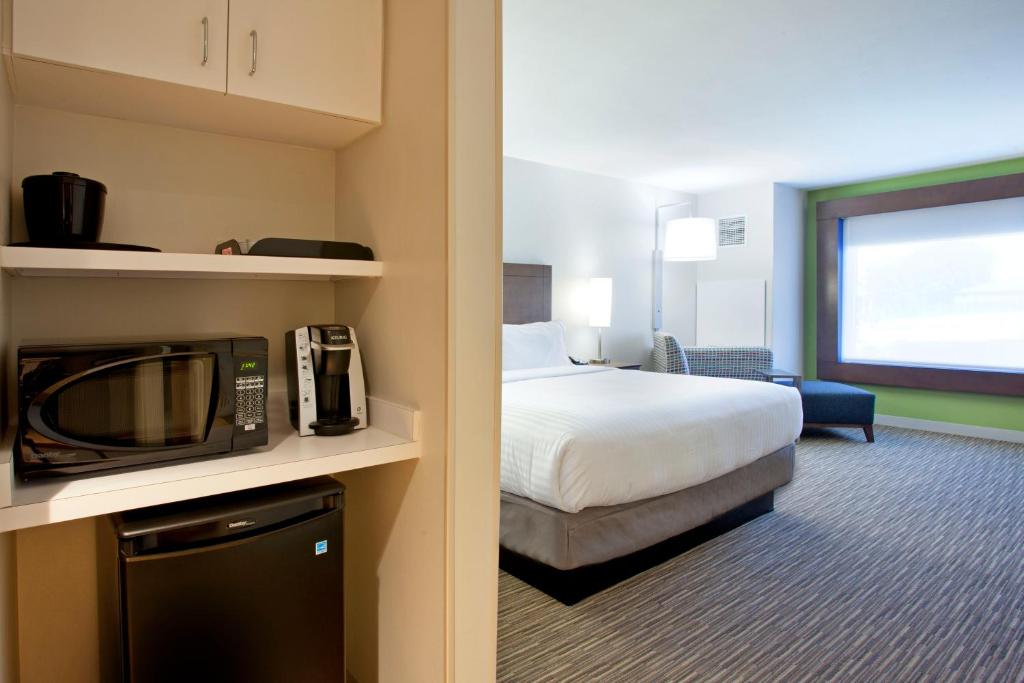 オースティンにあるHoliday Inn Express Hotel & Suites Austin Downtown - University by IHGのベッドとテレビがあるホテルの部屋