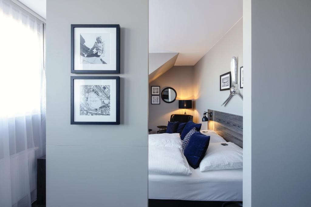 um quarto com uma cama e quadros na parede em Airporthotel Berlin-Adlershof em Berlim