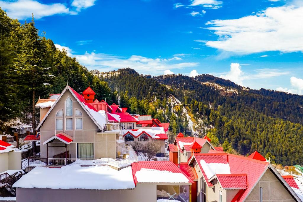a town in the mountains with snow on the roofs at Regenta Resort & Spa Mashobra in Shimla