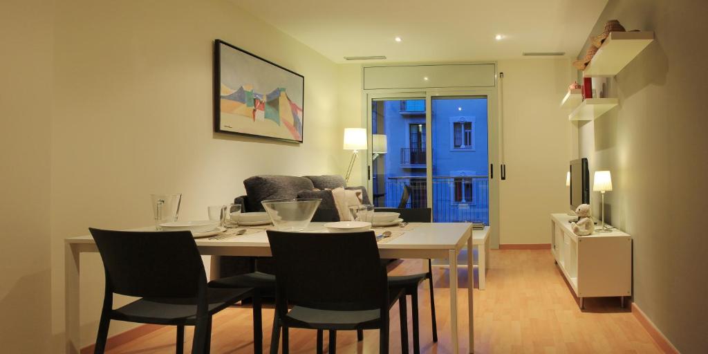 a living room with a dining room table and chairs at Alguera Apartments Industria in Barcelona