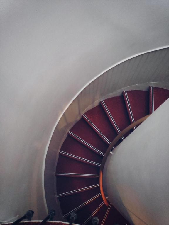 a spiral staircase in a building with red at Little Hôtel in Paris