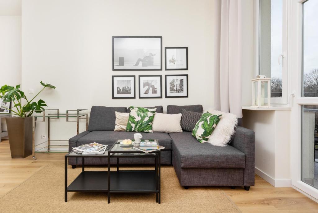 uma sala de estar com um sofá e uma mesa de centro em Apartments Warsaw Gagarina by Renters em Varsóvia
