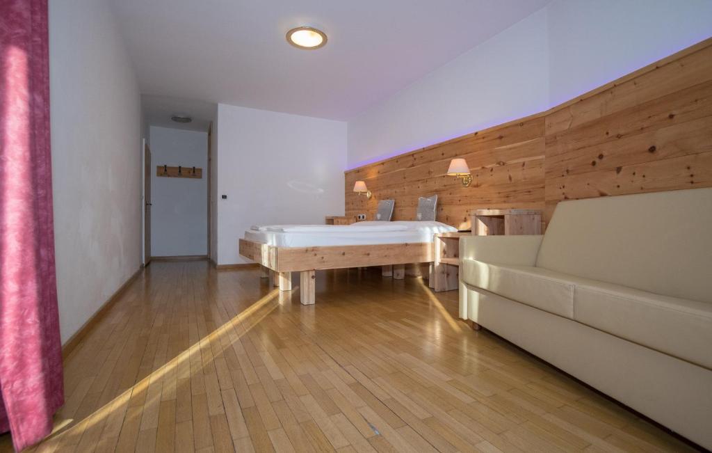 a large bedroom with a bed and a couch at Hotel Garni Snaltnerhof in Ortisei