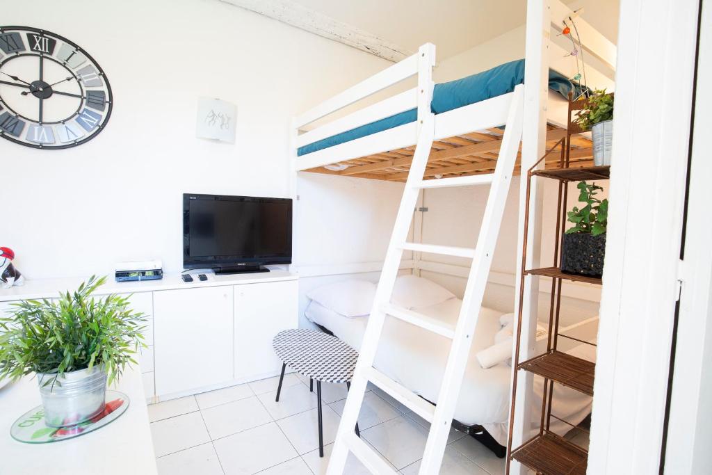 アンティーブにあるBNB RENTING Chez Dominique - Studio 2-4pers centre Antibes Fourmilliere 1erの二段ベッド1組、デスク(時計付)が備わる客室です。