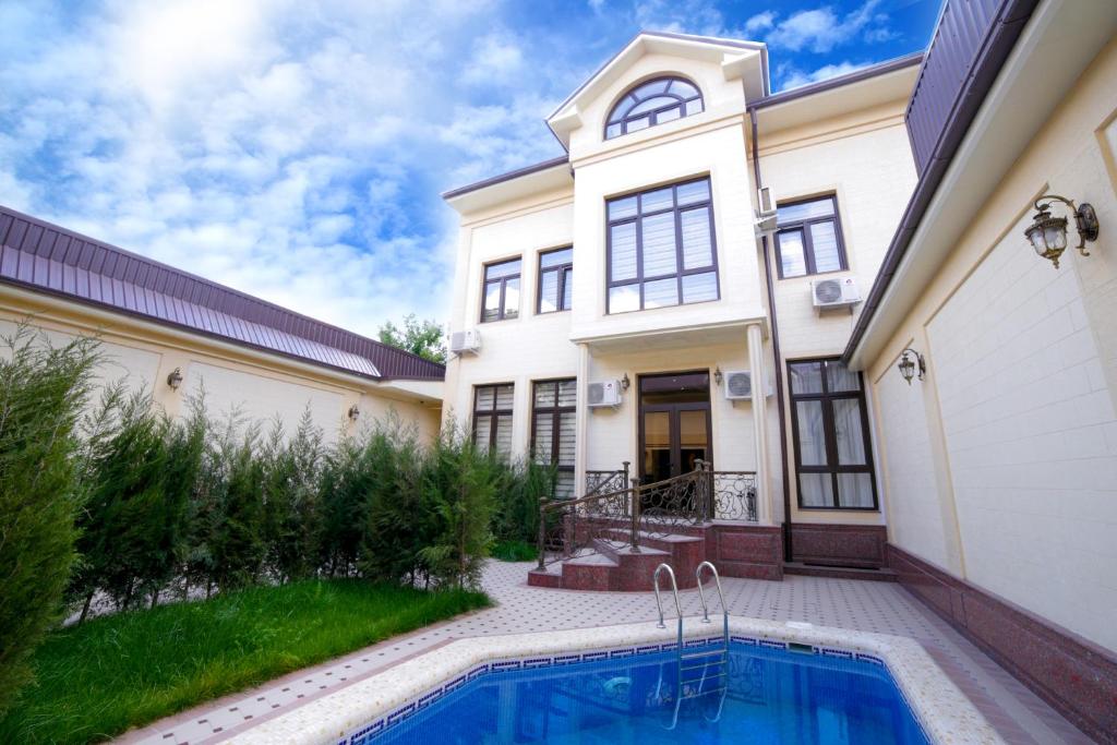 una casa con piscina frente a ella en Alliance Hotel Tashkent, en Tashkent