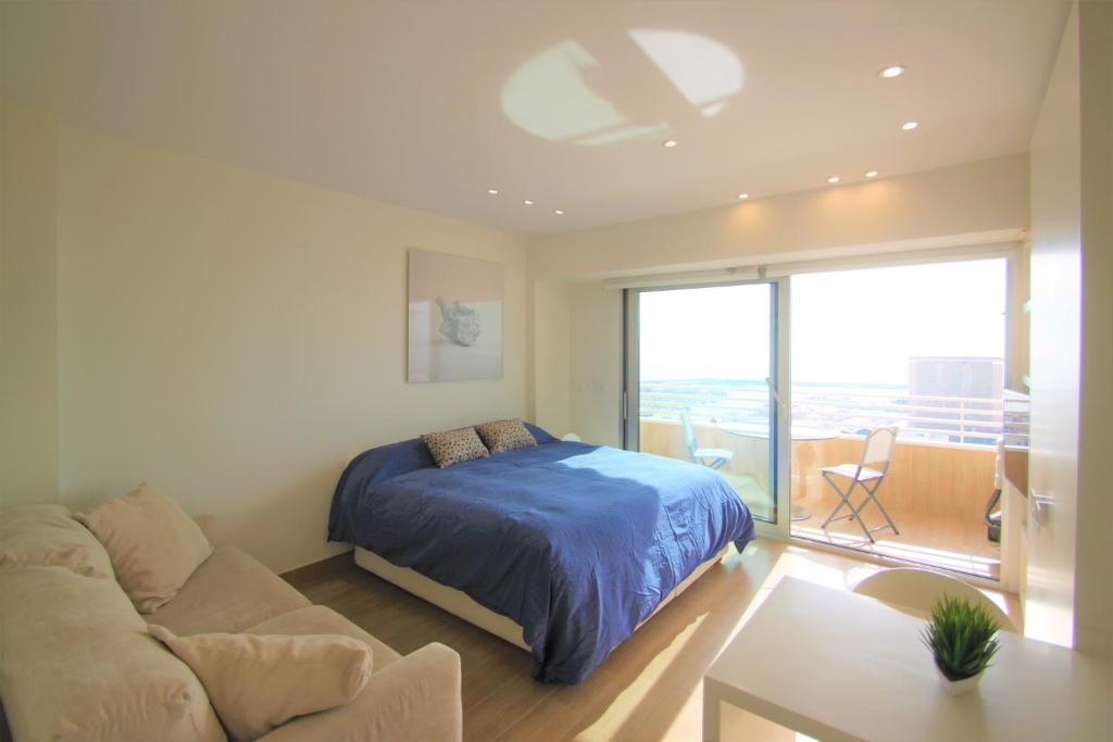 ein Schlafzimmer mit einem Bett und einem Sofa in der Unterkunft Estudio de Lujo CasaTuris en el Corazón de Alicante A114 in Alicante