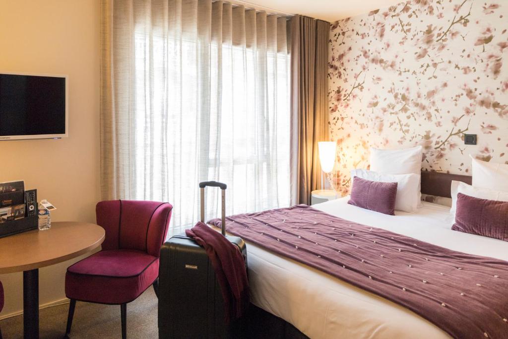 Habitación de hotel con cama, mesa y ventana en Hôtel L'Adresse, en Saint-Malo