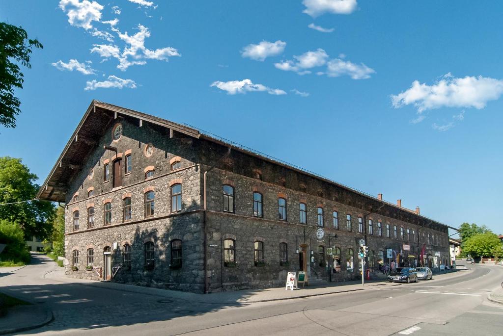 an old brick building on the side of a street at Kleinkunstbühne Zur Post beim John in Obing in Obing