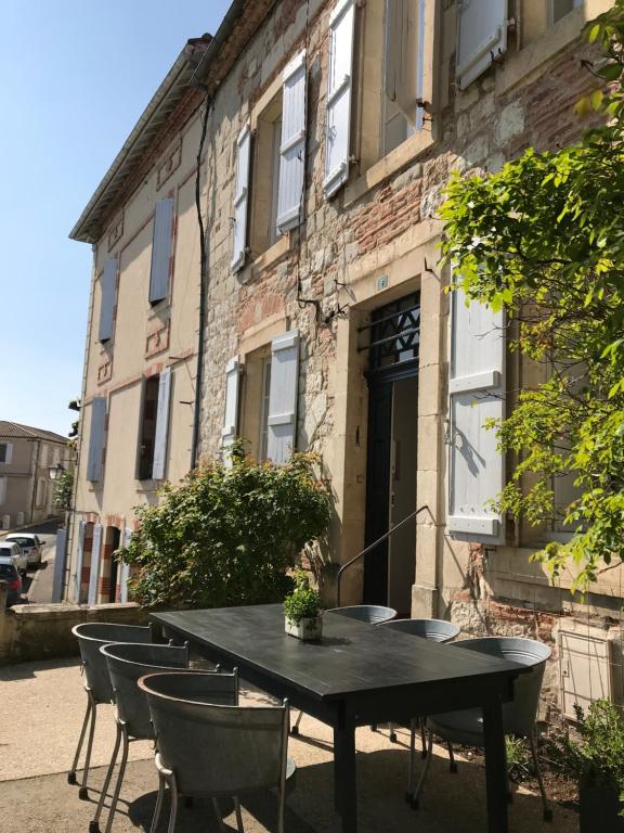 a black table and chairs in front of a building at l'autre maison in Penne-dʼAgenais