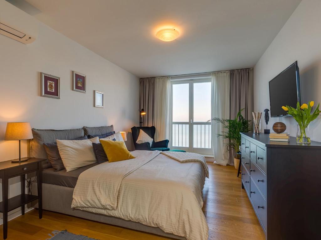 a bedroom with a large bed and a television at Bella Vista Premium Apartment in Poreč