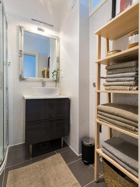 a bathroom with a sink and a mirror and towels at Bella Vista Premium Apartment in Poreč