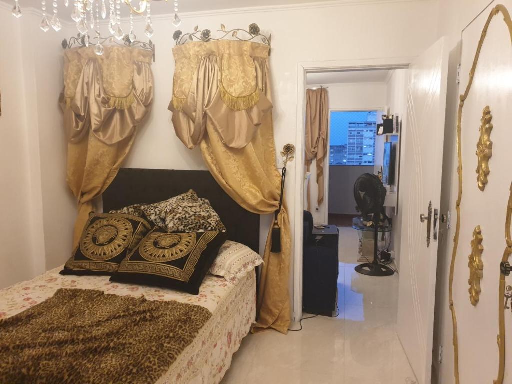 1 dormitorio con 1 cama con cortinas y lámpara de araña en Apartamento aconchegante e requintado republica !, en São Paulo