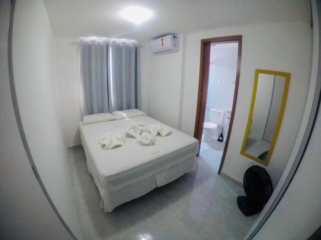1 dormitorio con cama blanca y espejo en STUDIO 102 - Manaíra, en João Pessoa