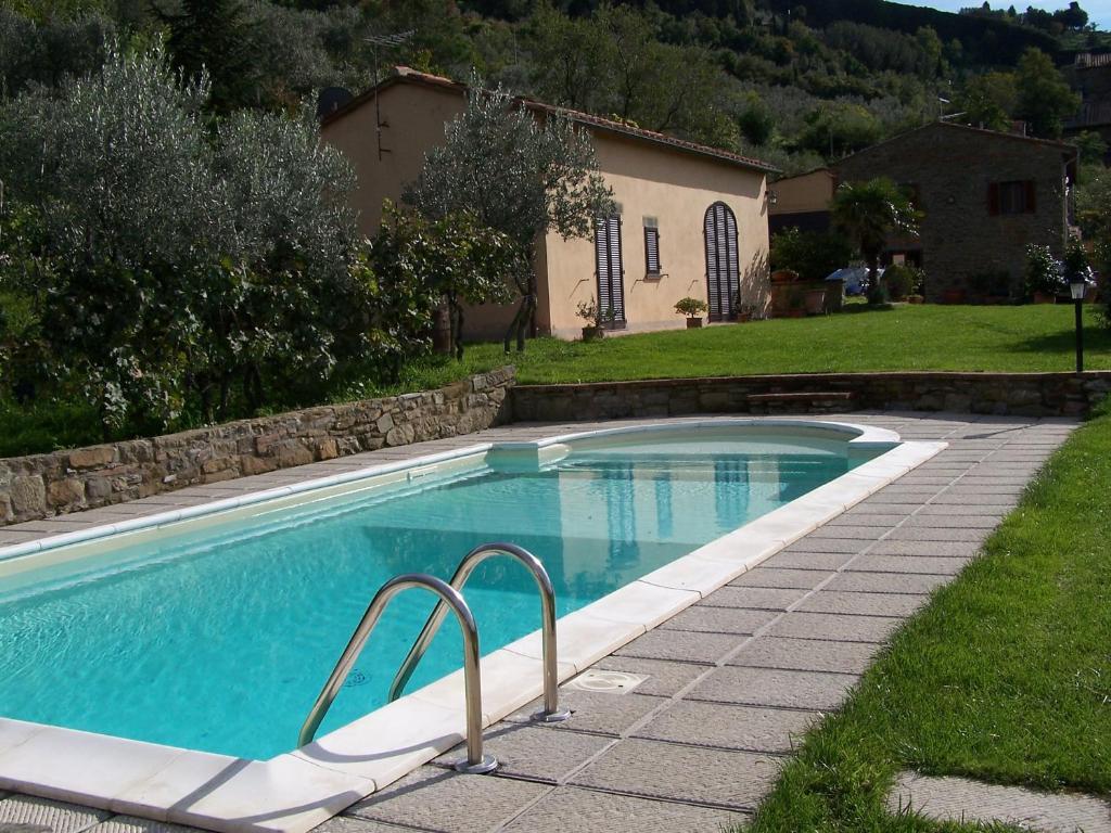 a swimming pool in a yard with a house at L'Orangerie in Cortona