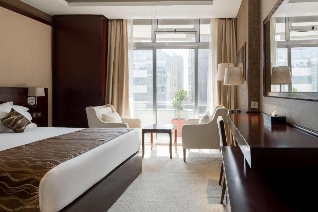 um quarto de hotel com uma cama e uma grande janela em Best Western Plus Pearl Addis em Addis Ababa