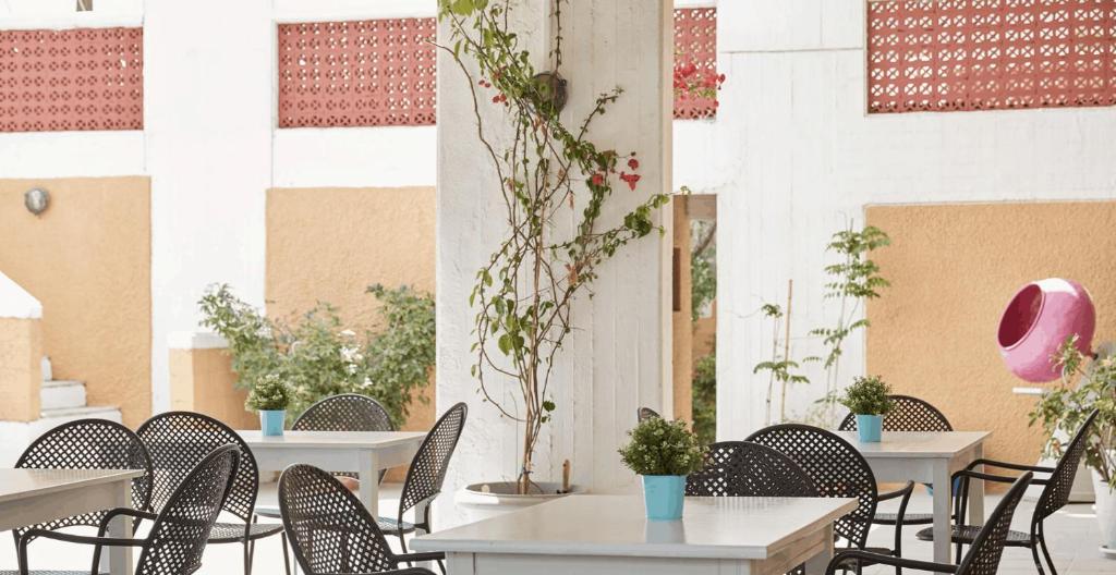 a group of tables and chairs in a patio at Mare Vista Hotel - Epaminondas in Batsi