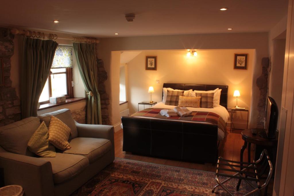 ein Schlafzimmer mit einem Bett und einem Sofa in der Unterkunft The Farmers Arms in Taunton