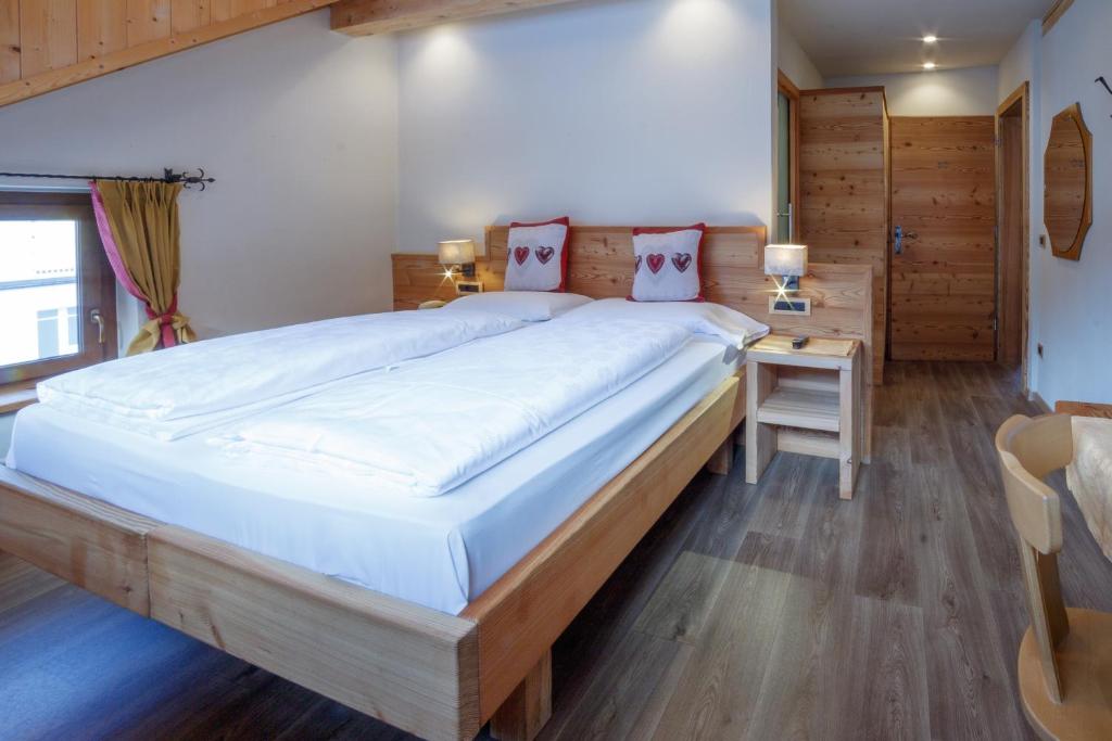 a bedroom with a large bed and a desk at Hotel Garni Snaltnerhof in Ortisei
