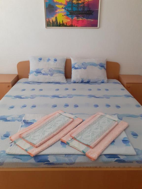 a bed with two towels on top of it at Apartmani BAKULE in Peštani