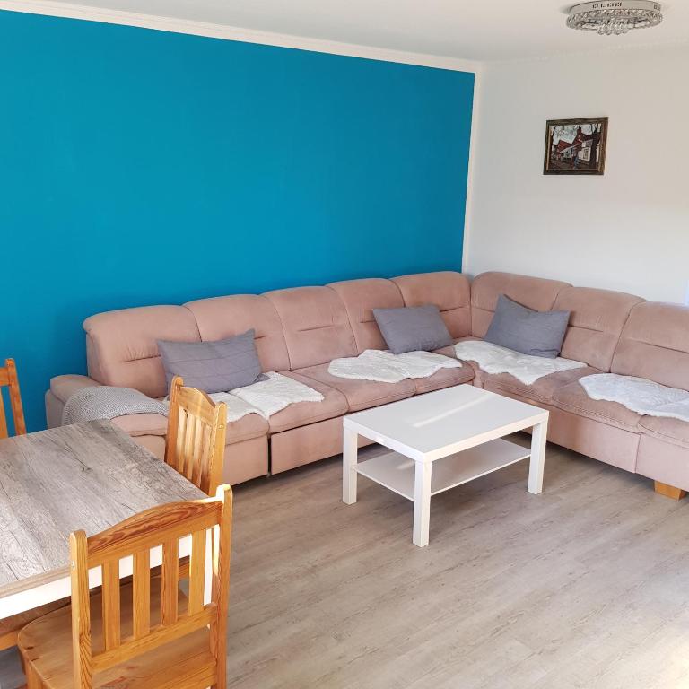 uma sala de estar com um sofá e uma mesa em Bungalow Streuwiese em Warnemünde