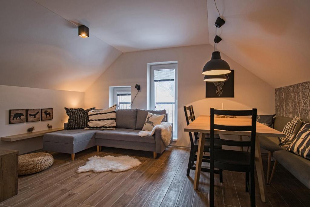 - un salon avec un canapé et une table dans l'établissement Ruprecht Apartment, à Vrchlabí