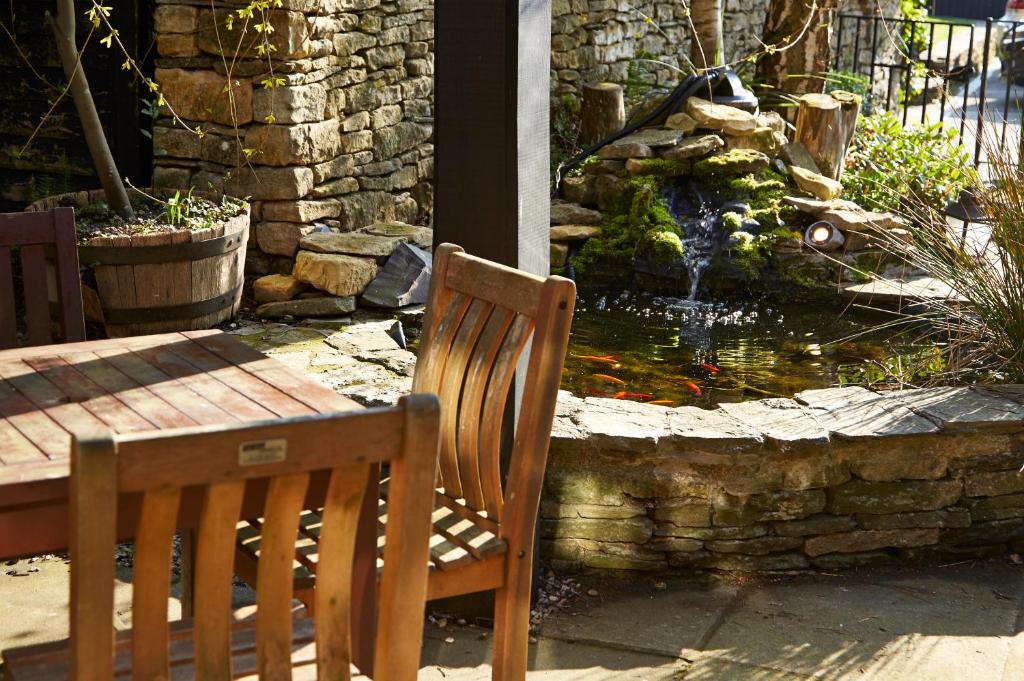 a table and chairs next to a water fountain at Old Manse Hotel by Greene King Inns in Bourton on the Water