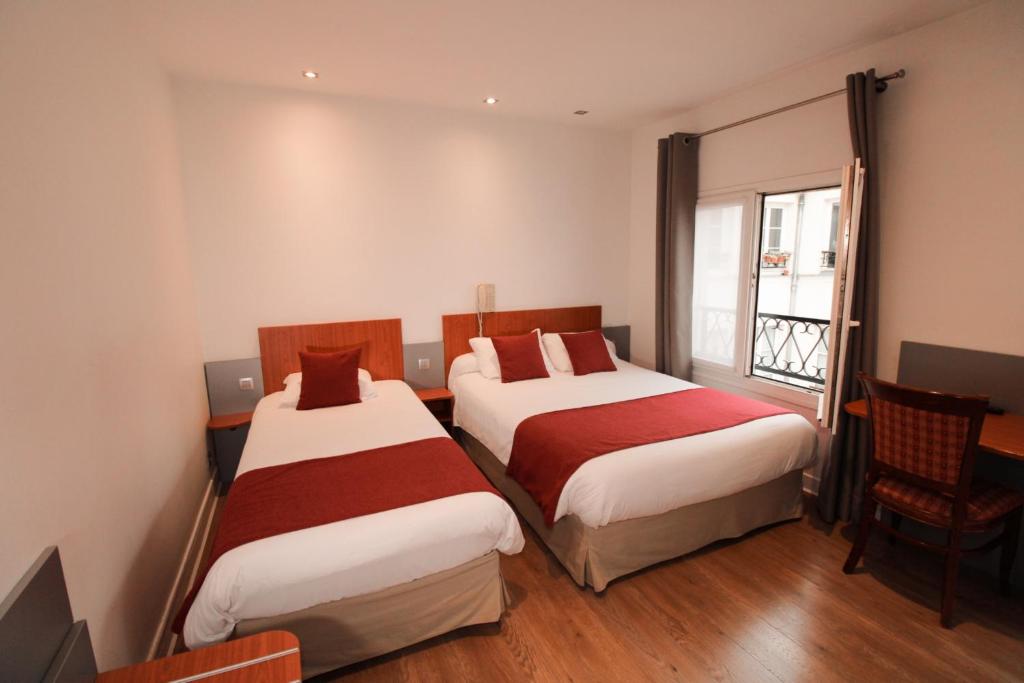 a hotel room with two beds and a window at Little Hôtel in Paris