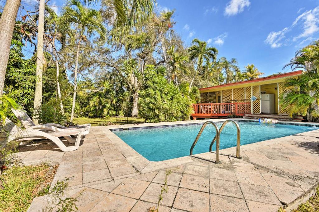 a swimming pool in front of a house at Quaint Central Miami Bungalow 10 Mi to Mid-Beach! in Miami