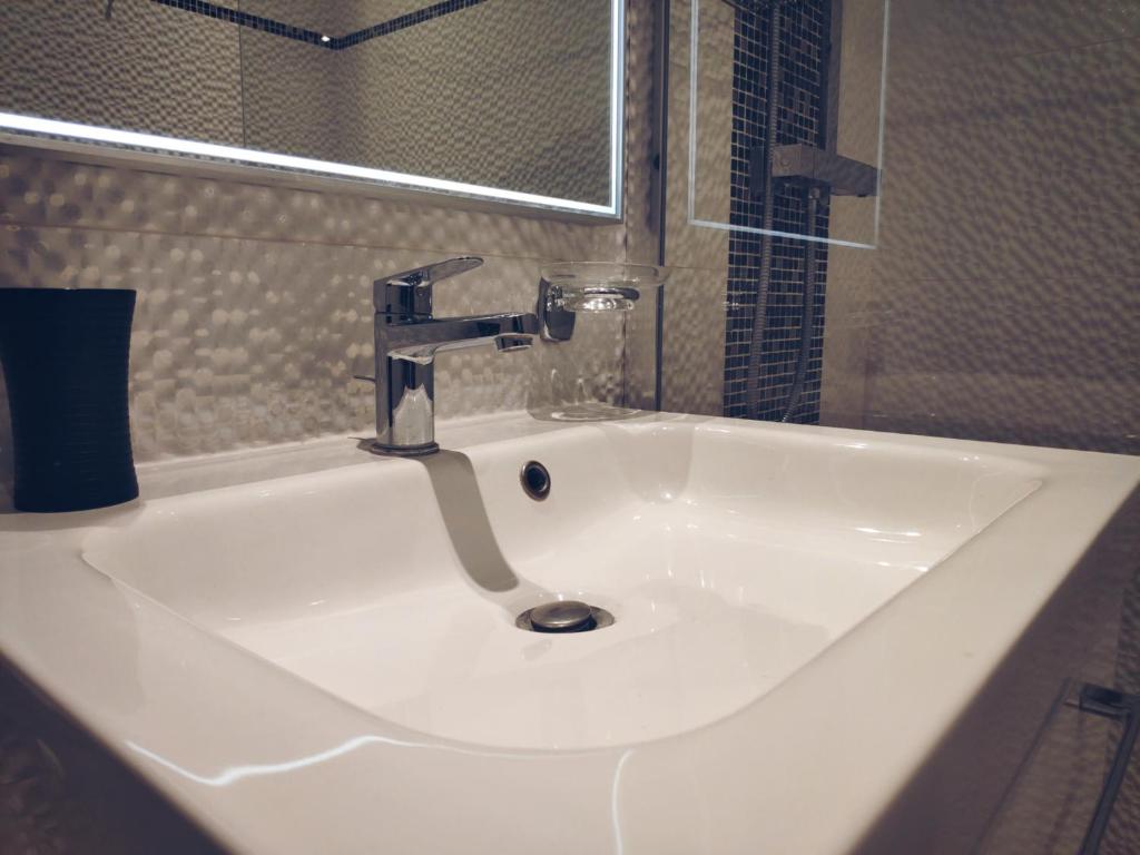 a white sink with a faucet in a bathroom at Little Hôtel in Paris