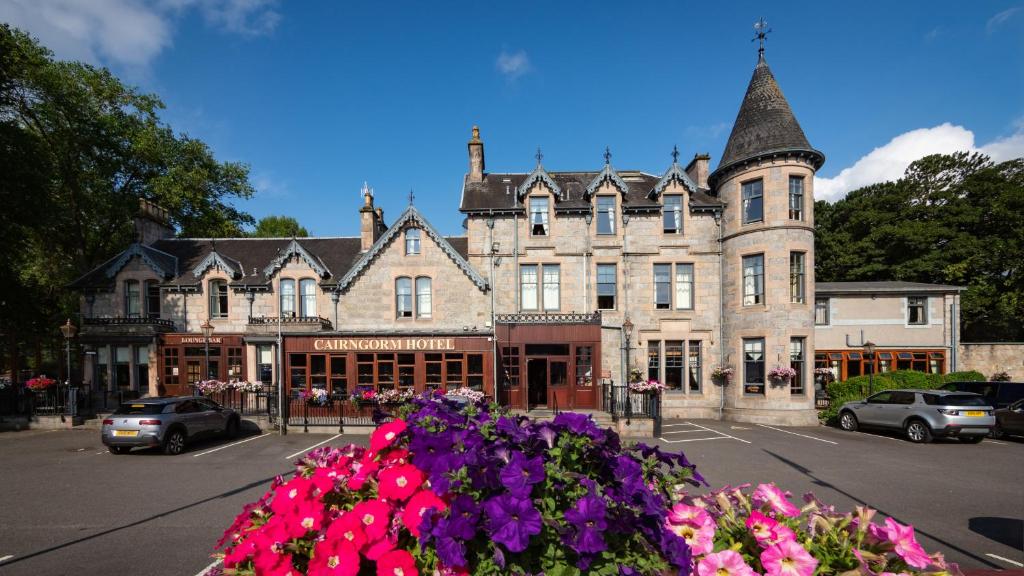 ein großes Gebäude mit Blumen davor in der Unterkunft Cairngorm Hotel in Aviemore
