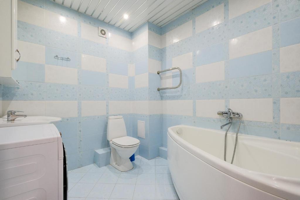baño azul y blanco con bañera y aseo en ОК! Никитина, 20 №2, en Tomsk