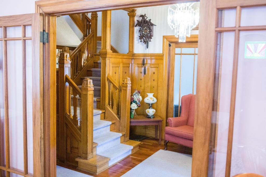 a wooden staircase in a home with a pink chair at The Harbour House in Charlottetown