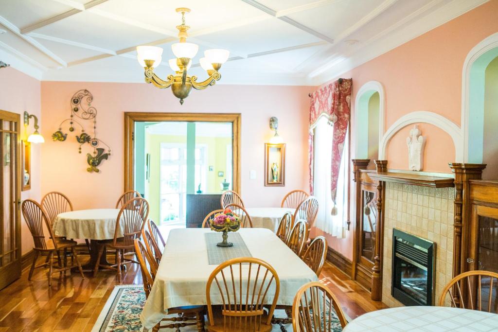 a dining room with a table and chairs and a fireplace at The Harbour House in Charlottetown