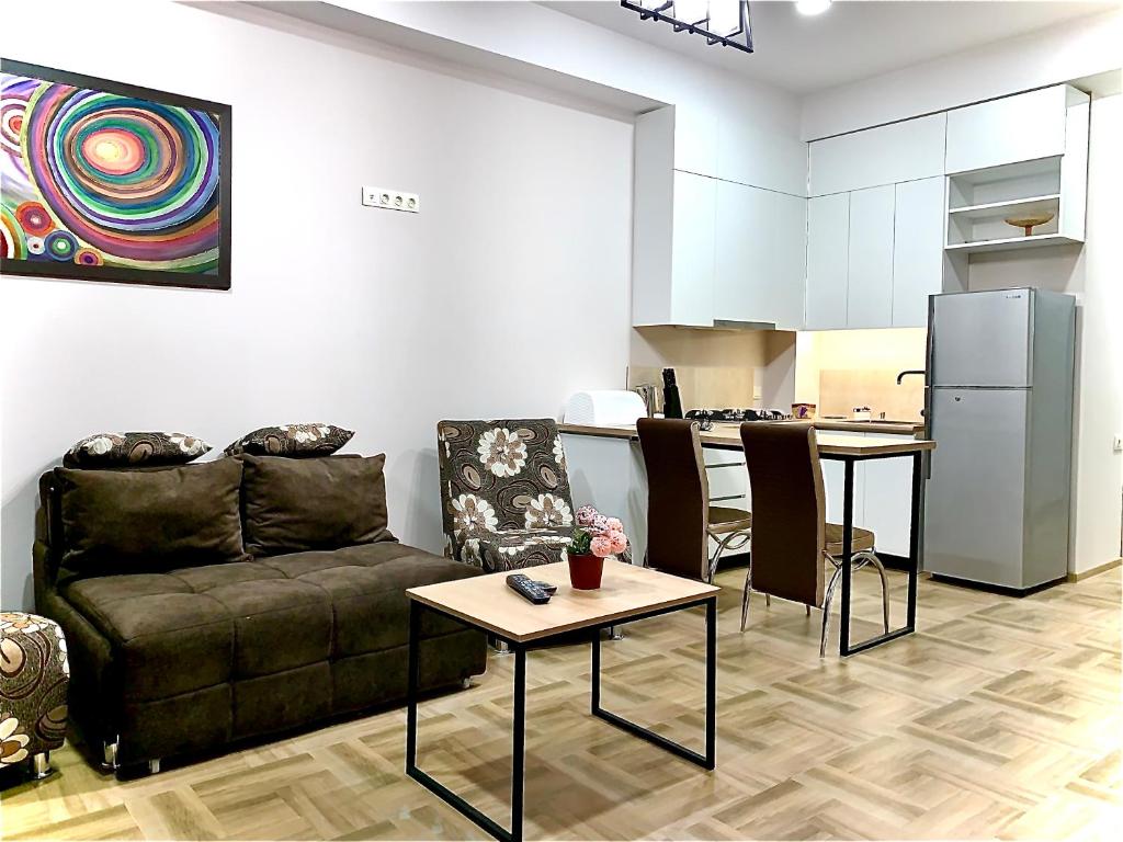sala de estar con sofá y cocina en TOMASO, en Tiflis