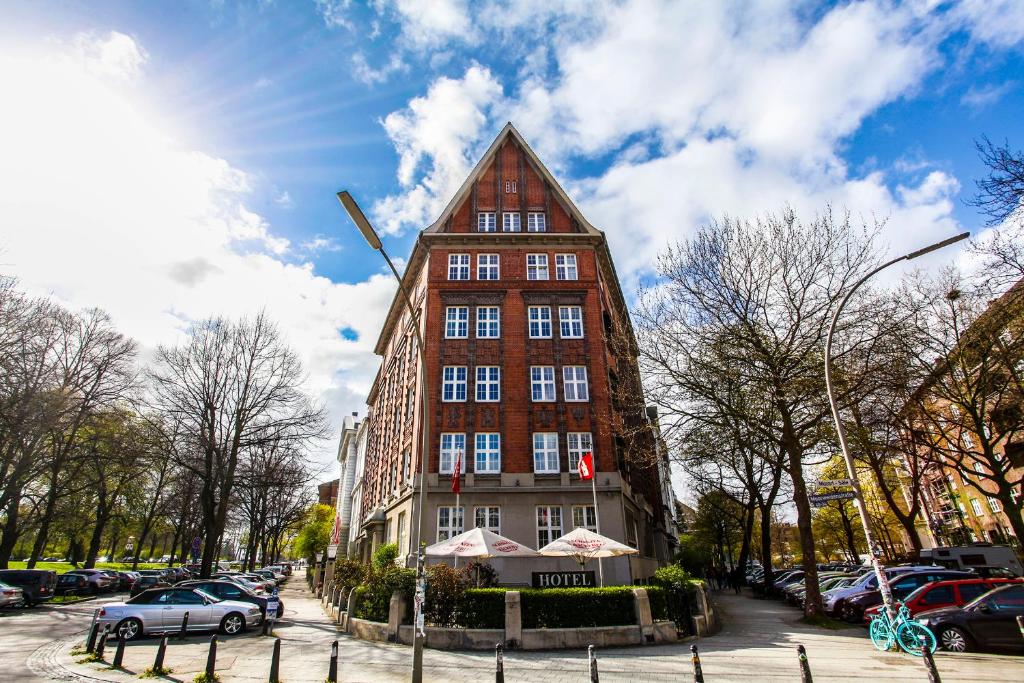 un edificio alto de color rojo con techo puntiagudo en Hotel Wagner im Dammtorpalais en Hamburgo