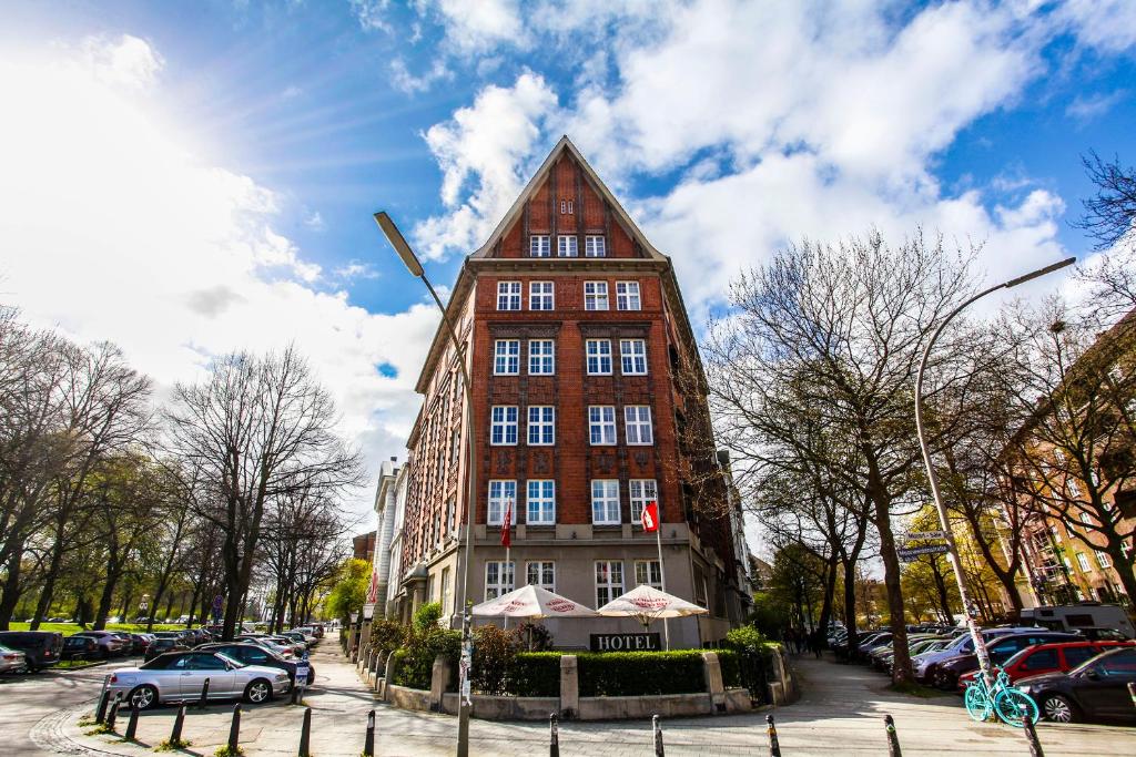 a tall red building with a pointed roof at Hotel Wagner im Dammtorpalais in Hamburg