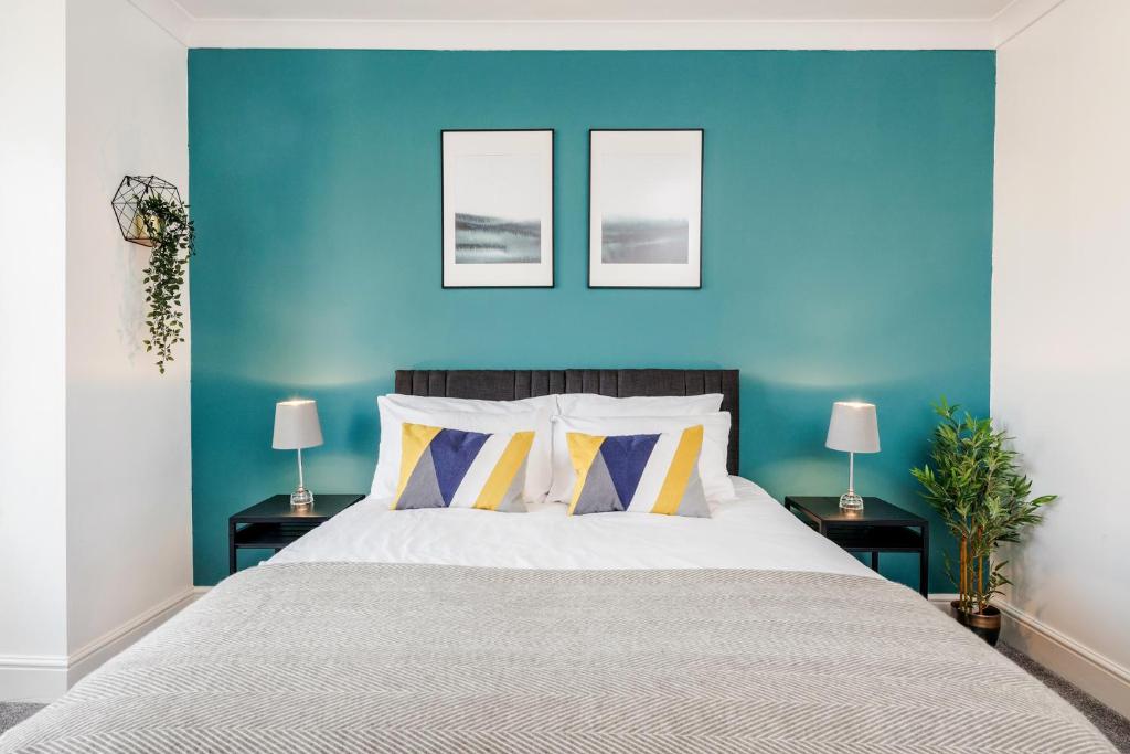 a bedroom with a blue wall and a bed at Luxury Apartment 2bed & Parking - East London - by Damask Homes in Ilford