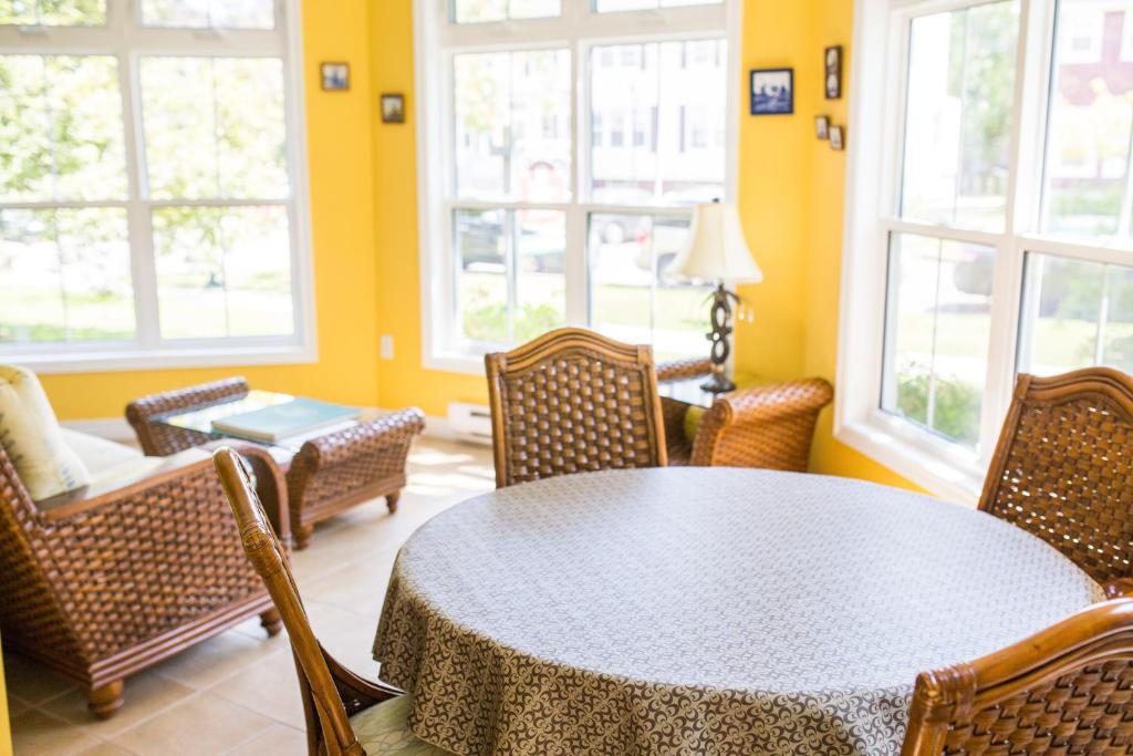 a dining room with a table and chairs and windows at The Harbour House in Charlottetown