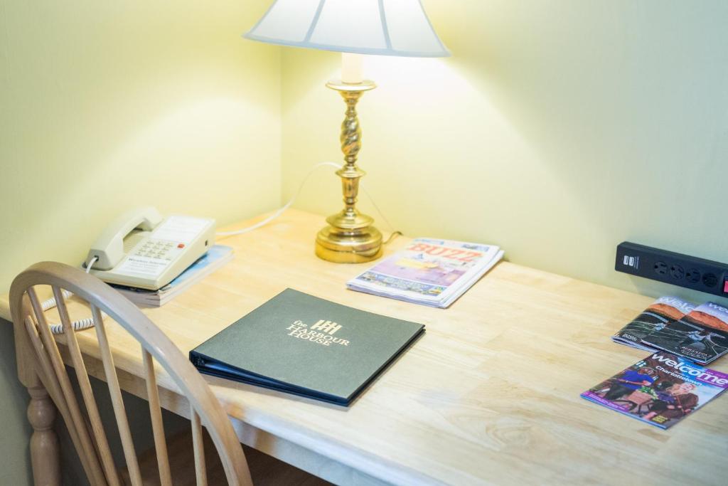 a desk with a lamp and a book and a phone at The Harbour House in Charlottetown