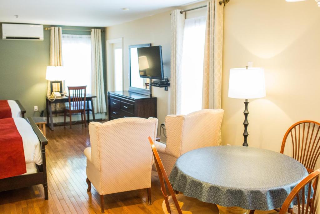 a living room with a bed and a table and chairs at The Harbour House in Charlottetown
