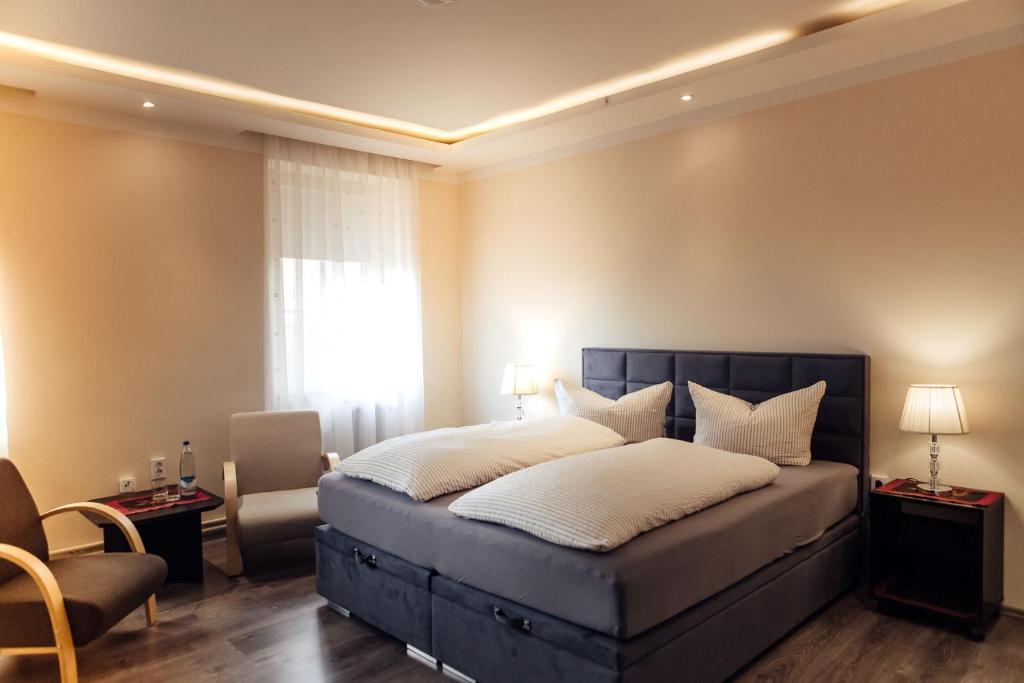 ein Schlafzimmer mit einem großen Bett und einem Stuhl in der Unterkunft Hotel und Restaurant Peking in Riesa