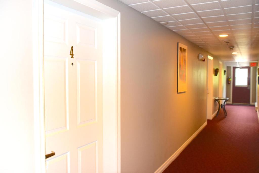 a hallway with a white door and a hallway at The Harbour House in Charlottetown