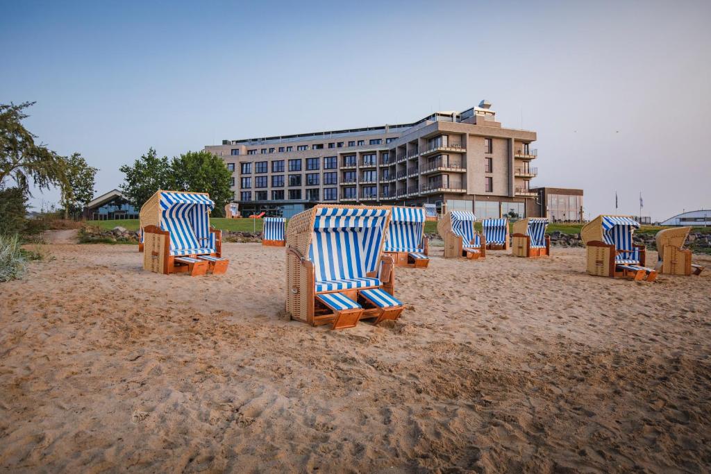 a row of beach chairs sitting on a sandy beach at ARBOREA Marina Resort Neustadt in Neustadt in Holstein