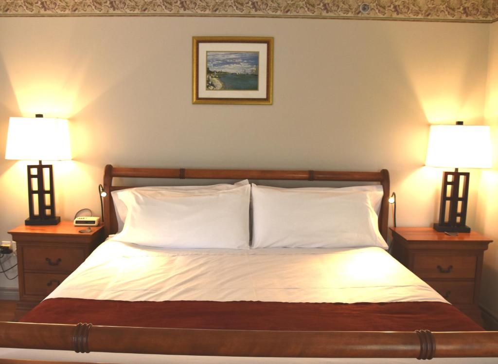 a bedroom with a bed with two lamps on both sides at The Harbour House in Charlottetown