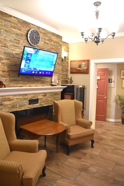 a living room with a tv on a brick wall at The Harbour House in Charlottetown