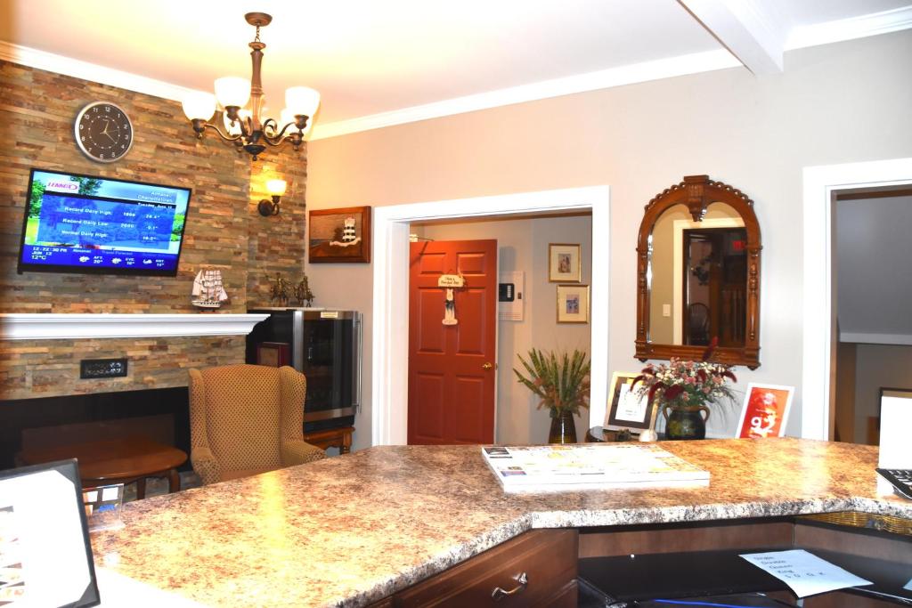 a kitchen with a counter and a tv on a brick wall at The Harbour House in Charlottetown