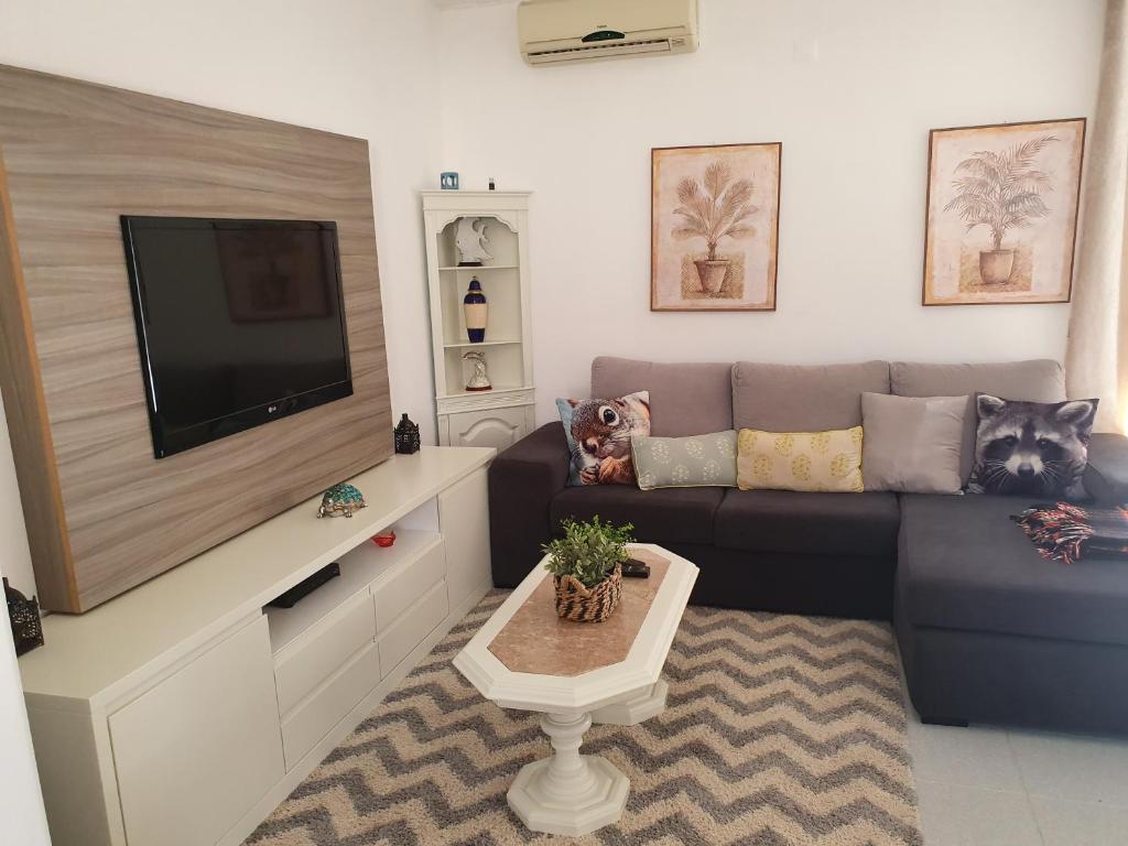 sala de estar con sofá y TV de pantalla plana en Casa Bento by Umbral, en Albufeira