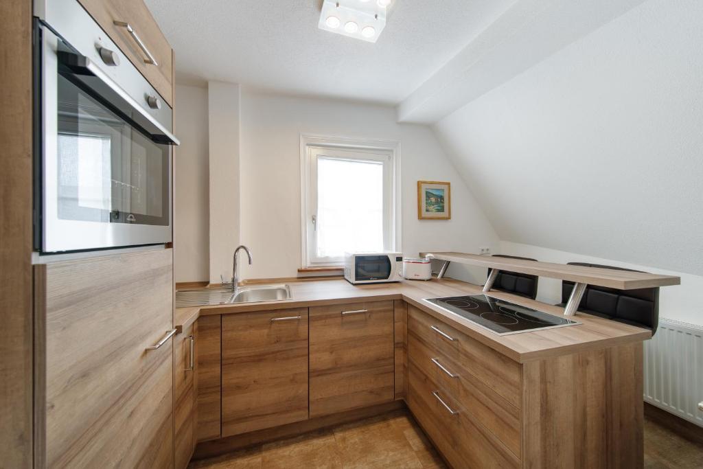 una cocina con armarios de madera y fregadero en Appartamenti Quattro Ducati, en Göppingen