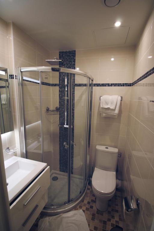 a bathroom with a shower and a toilet and a sink at Little Hôtel in Paris