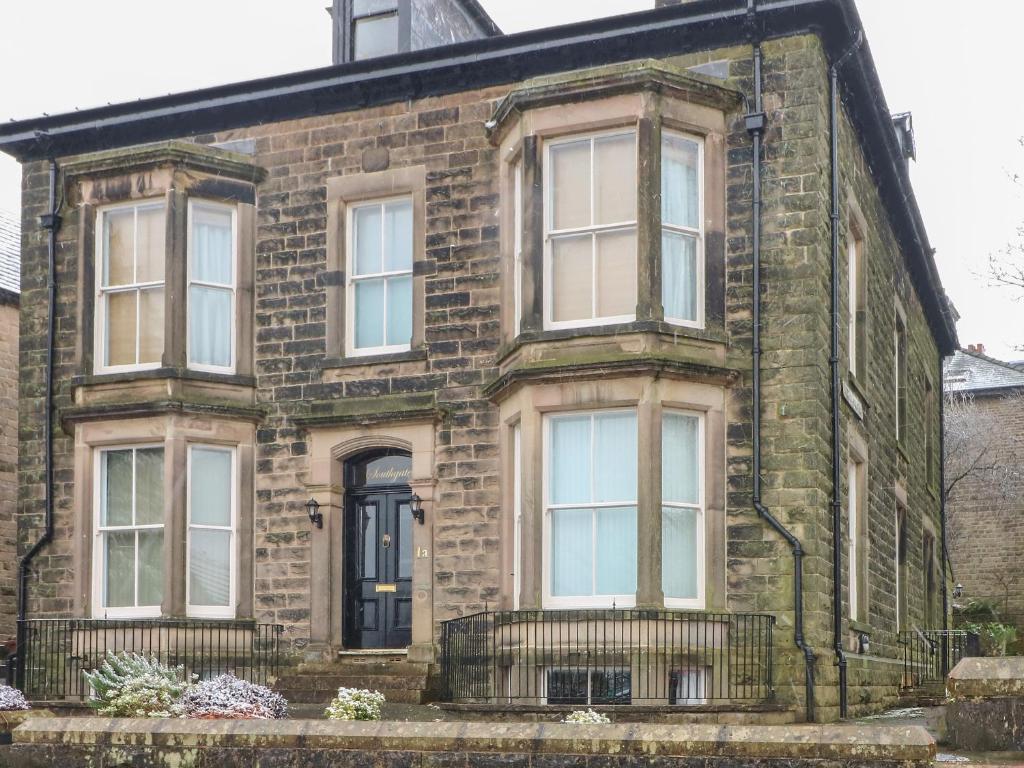 ein altes Backsteinhaus mit schwarzer Tür in der Unterkunft 1 Southgate in Buxton